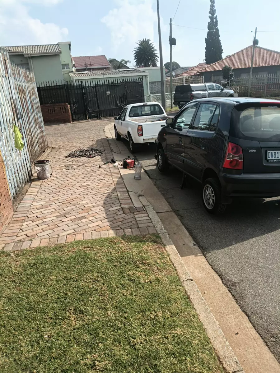 Residential street scene with parked cars and a paved driveway