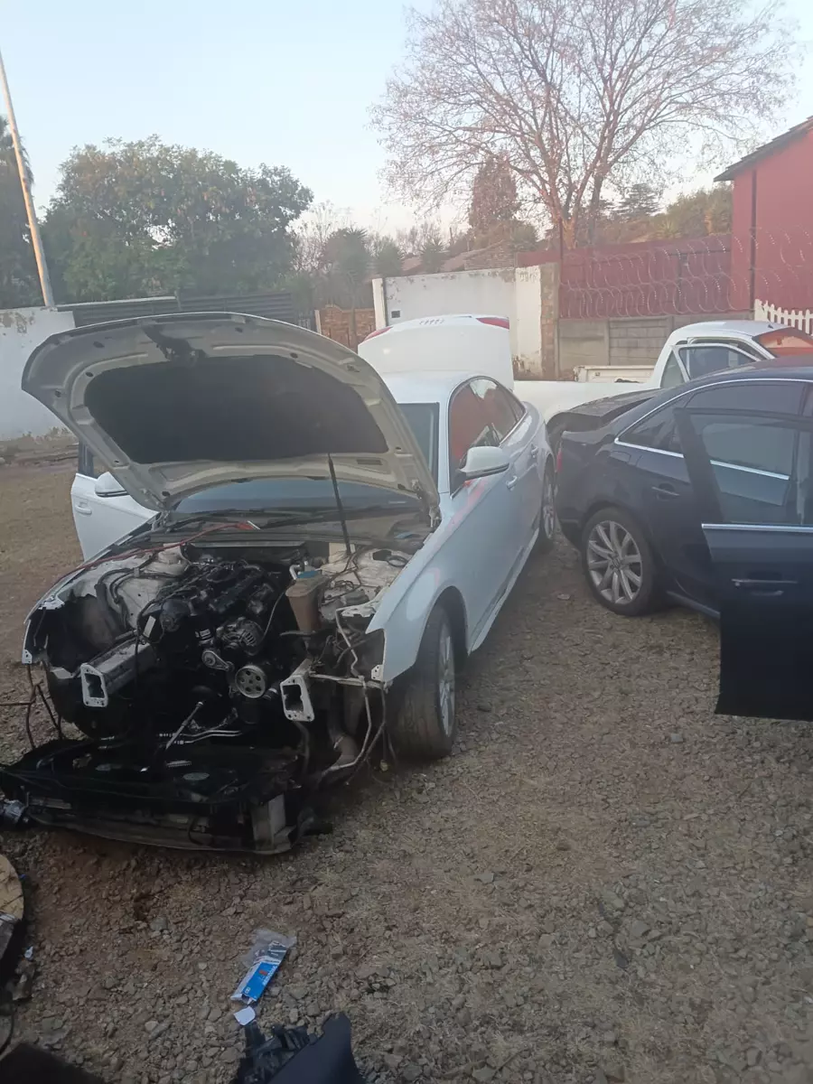 White car undergoing repairs with front end dismantled