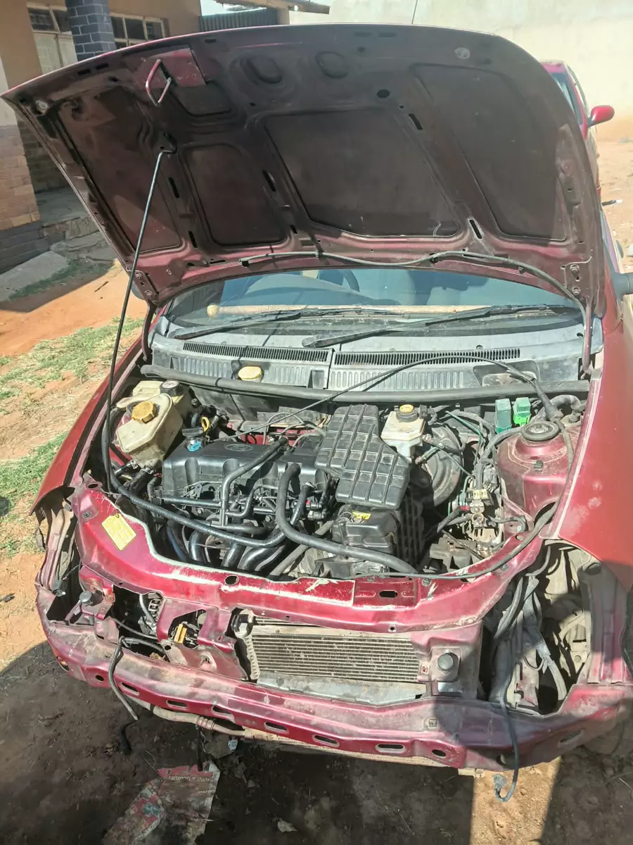 Maroon car with open hood and dismantled front end