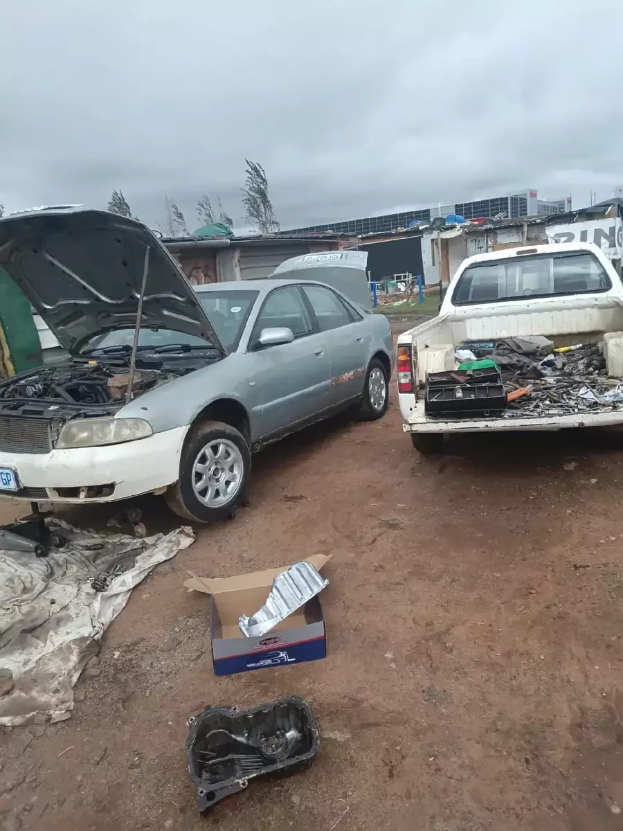 Outdoor automotive repair yard with cars and spare parts