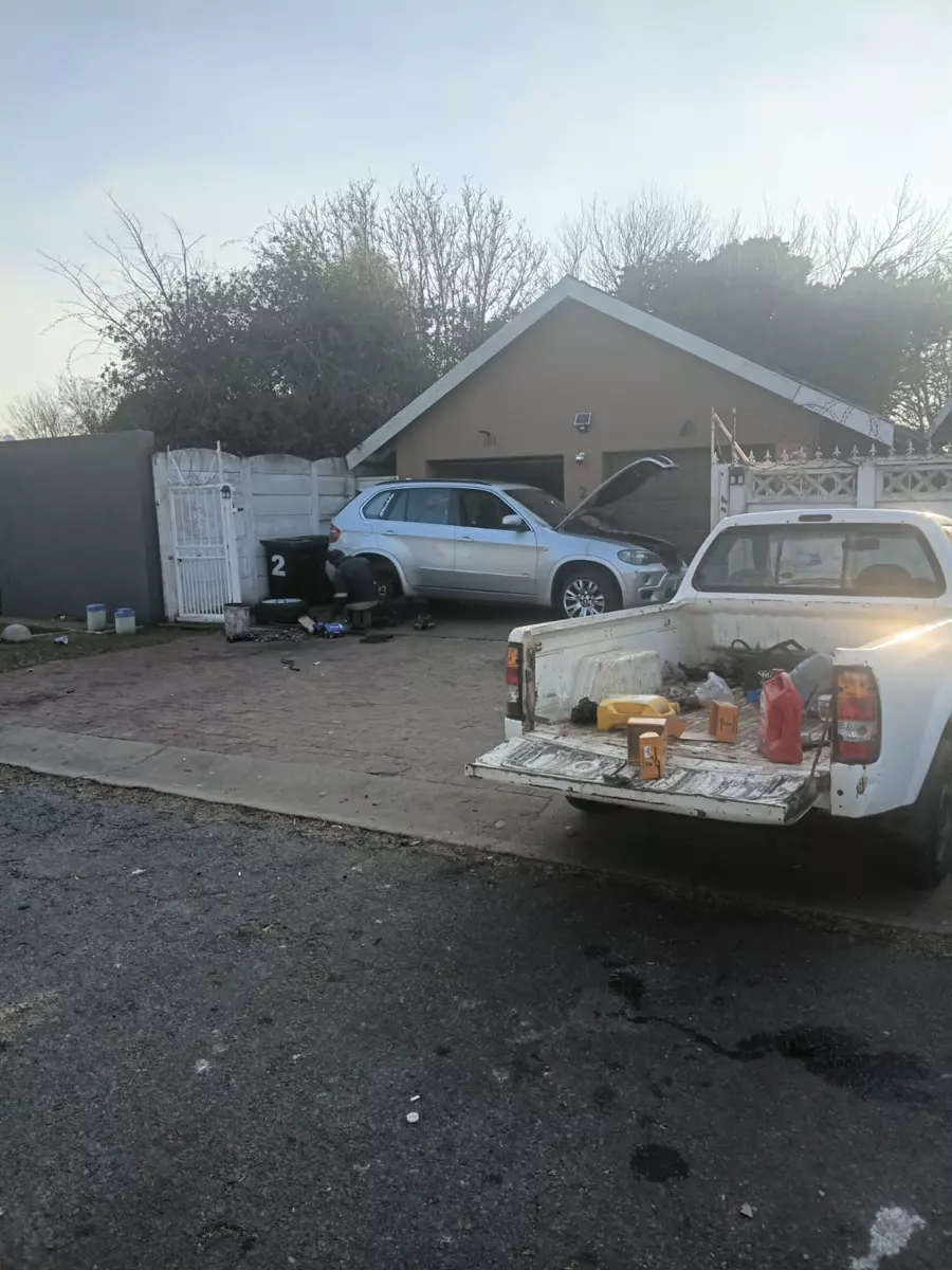 Cars parked in a driveway undergoing repair